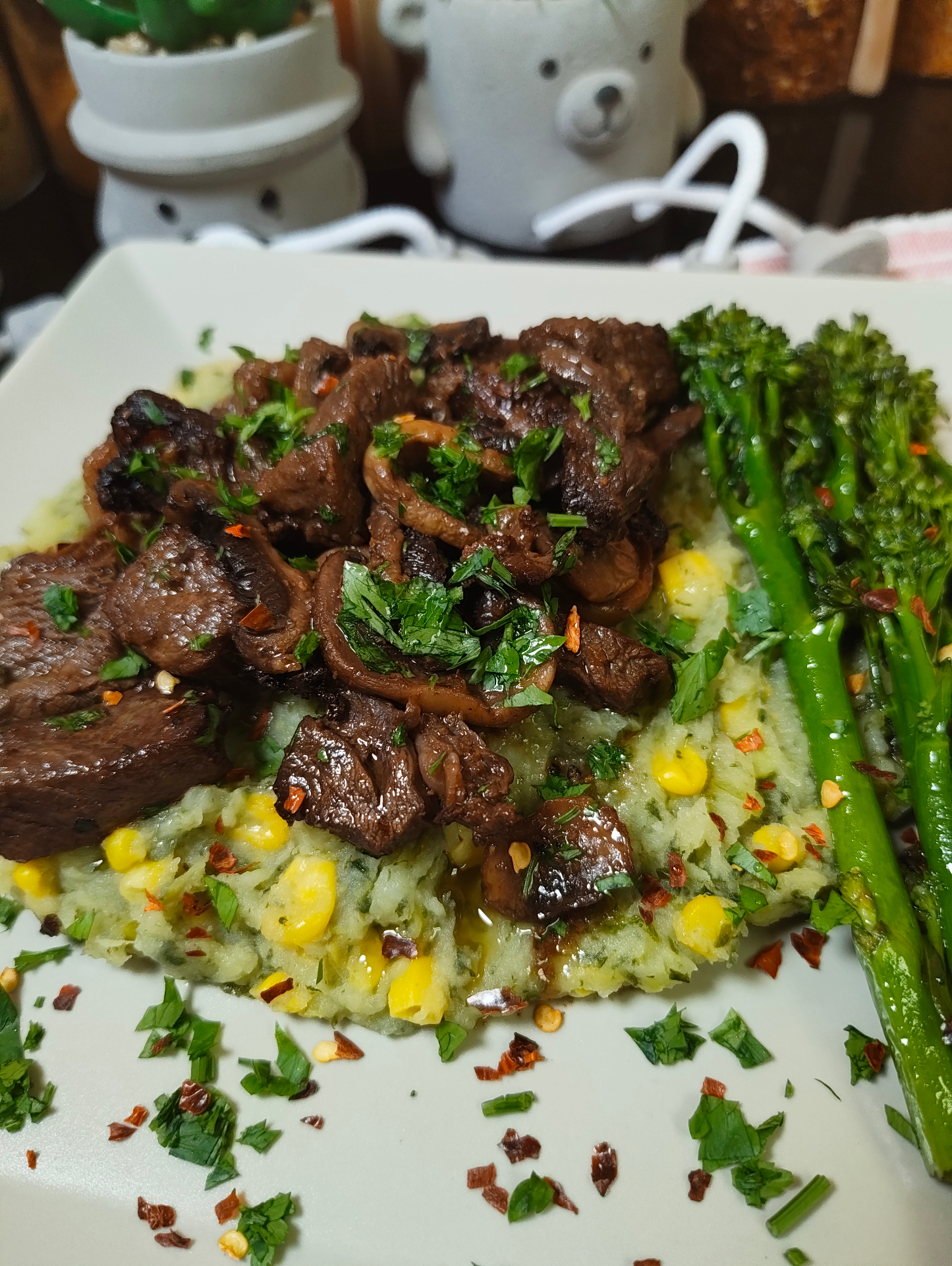 Close-up of air fryer beef and mushrooms with chopped parsley on mokimo, with tenderstem broccoli beside it