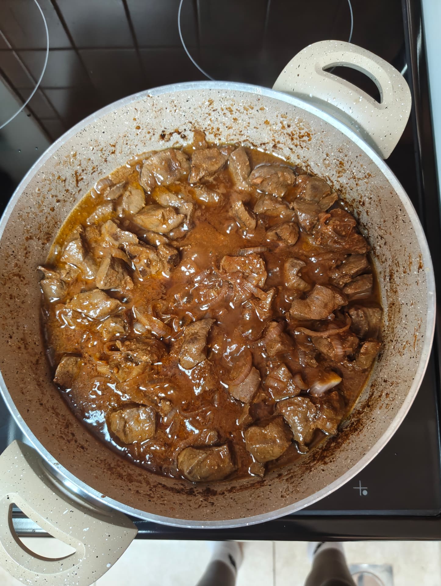 Beef liver and onions cooking in a rich tomato based sauce