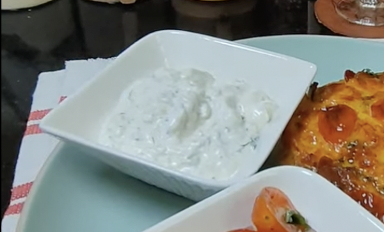 Creamy cucumber yoghurt dip with dill served alongside a breakfast bake and a Greek style salad