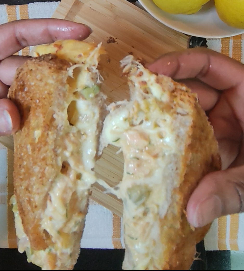 Salmon melt pulled apart showing melted cheese and salmon filling