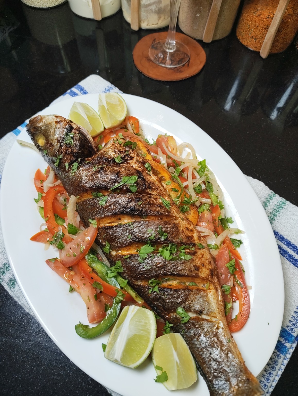 Air Fryer Sea Bass on a white platter with lime wedges
