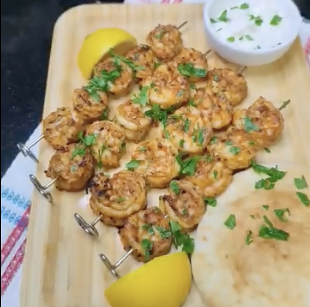 Easy air fryer shrimp skewers served with lemon, garlic sauce and flatbread