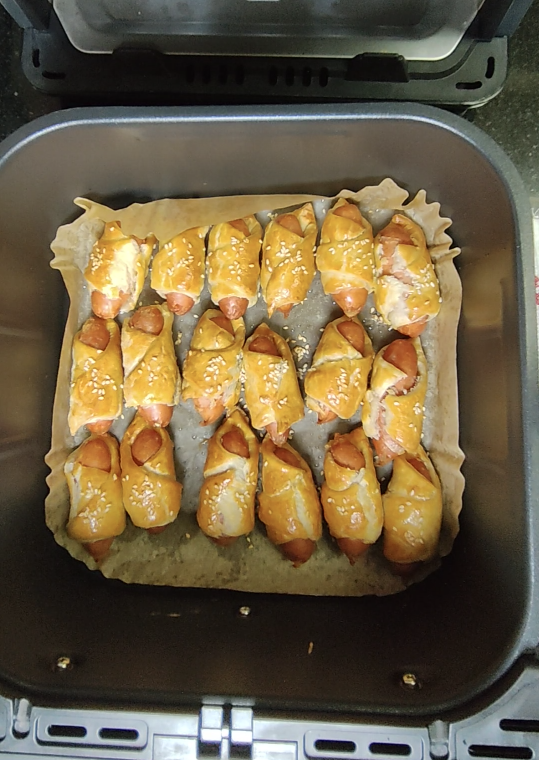 Pastry wrapped sausage pieces cooked in an air fryer basket