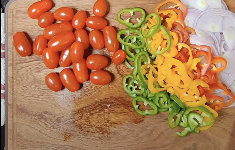 Cherry tomatoes, sliced colourful bell peppers and onion prepared for rocket salad