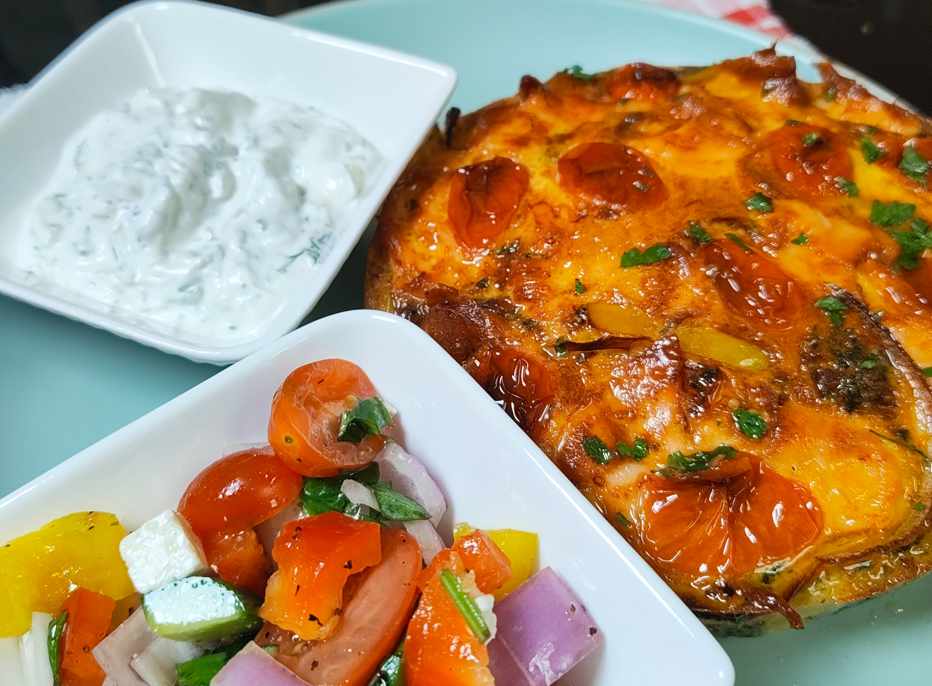 Close up of the golden smoked salmon and egg breakfast bake with cherry tomatoes and parsley