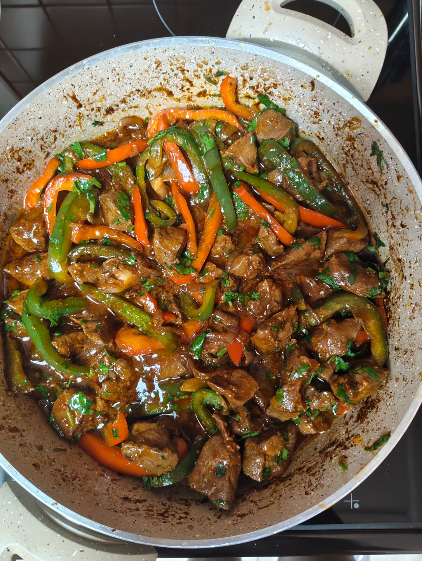 Finished beef liver stew with peppers and fresh coriander in a pan