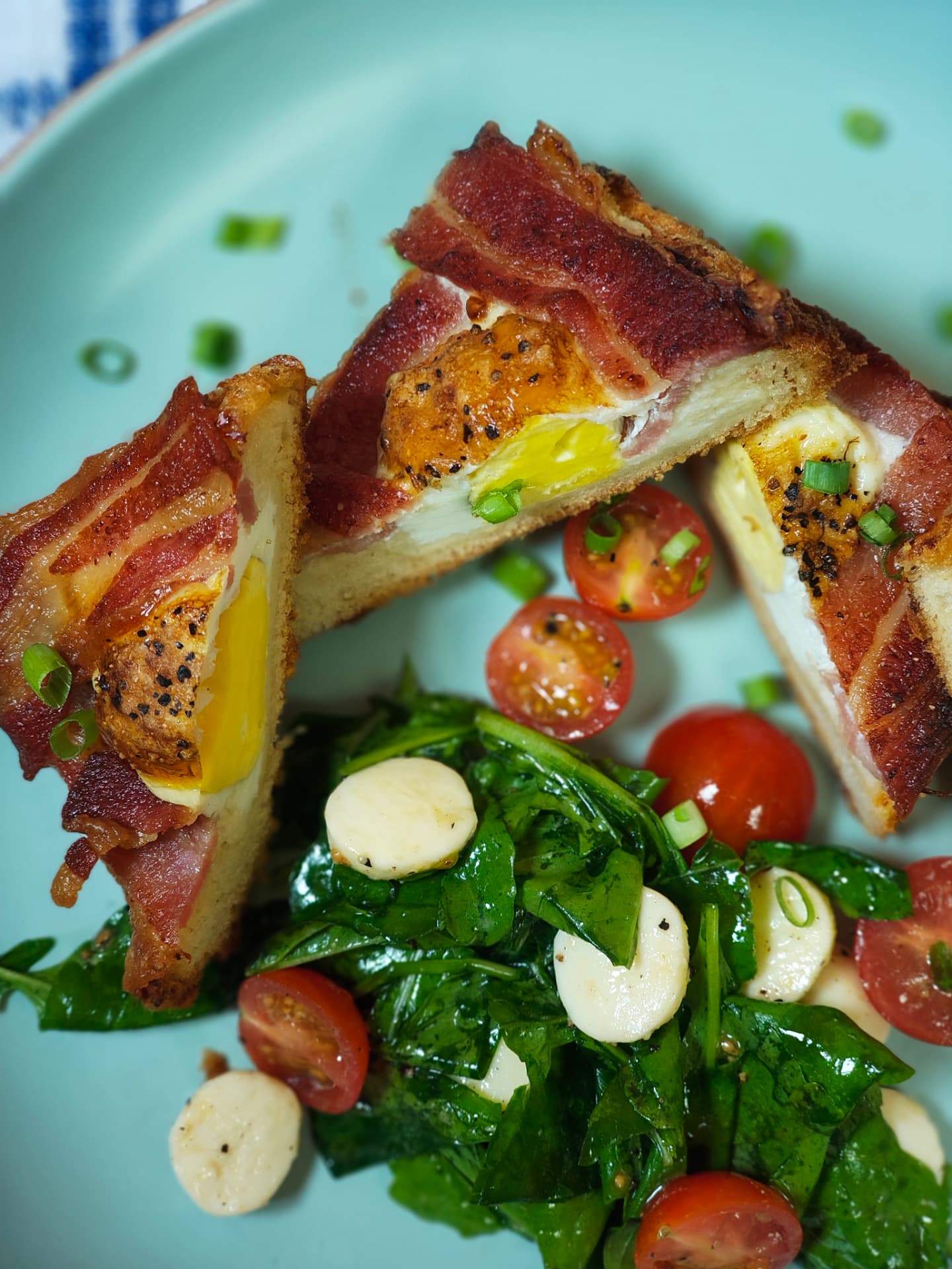 Close up of air fryer bacon and eggs on toast with a fresh rocca salad