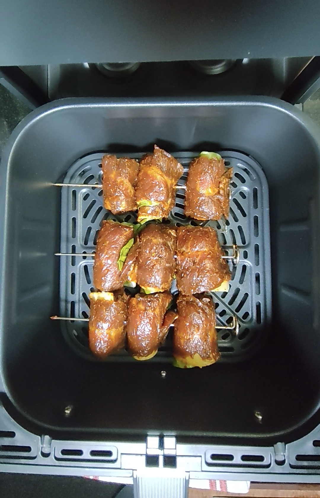 Food cooking inside an air fryer basket