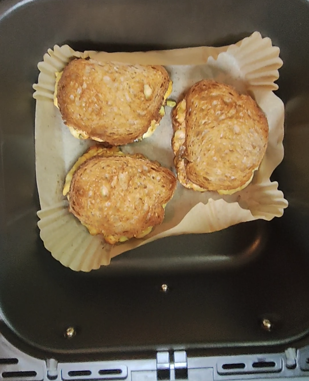 Three salmon melt sandwiches in an air fryer basket