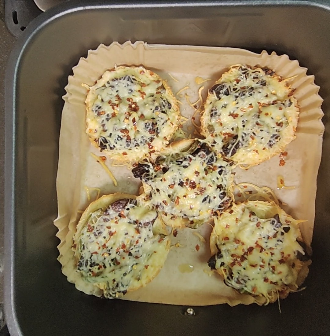 Food holding a parchment-style liner securely inside an air fryer basket