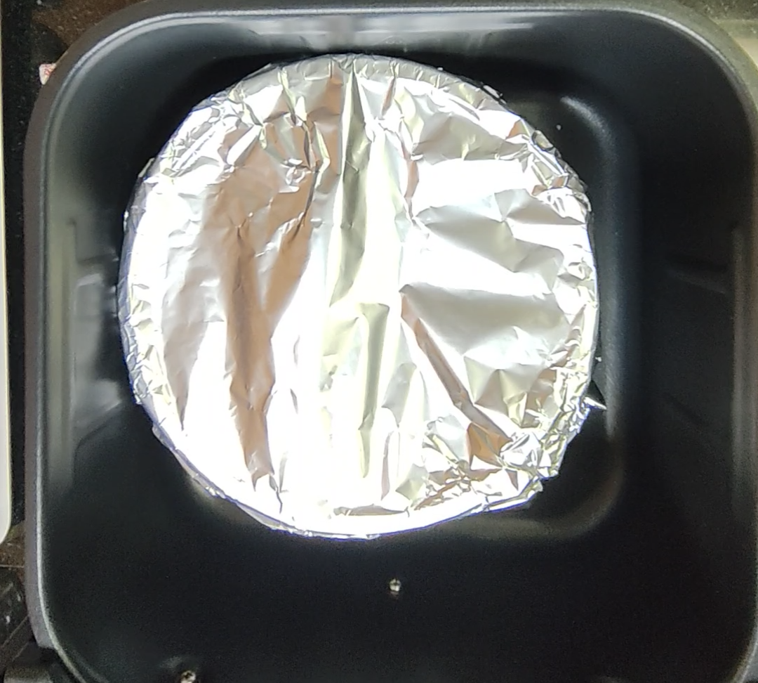 Air Fryer Spicy Beef Rice cooking in a dish covered with foil
