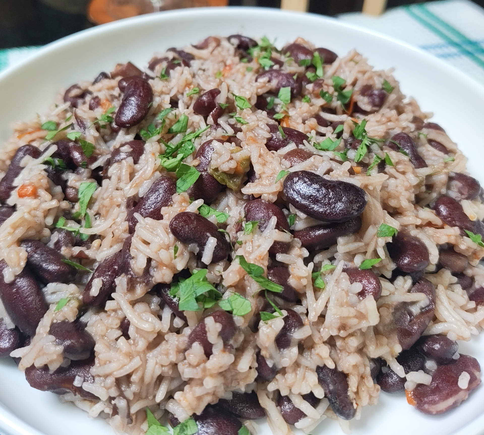 Close up of kidney beans and rice with red and green bell peppers and parsley